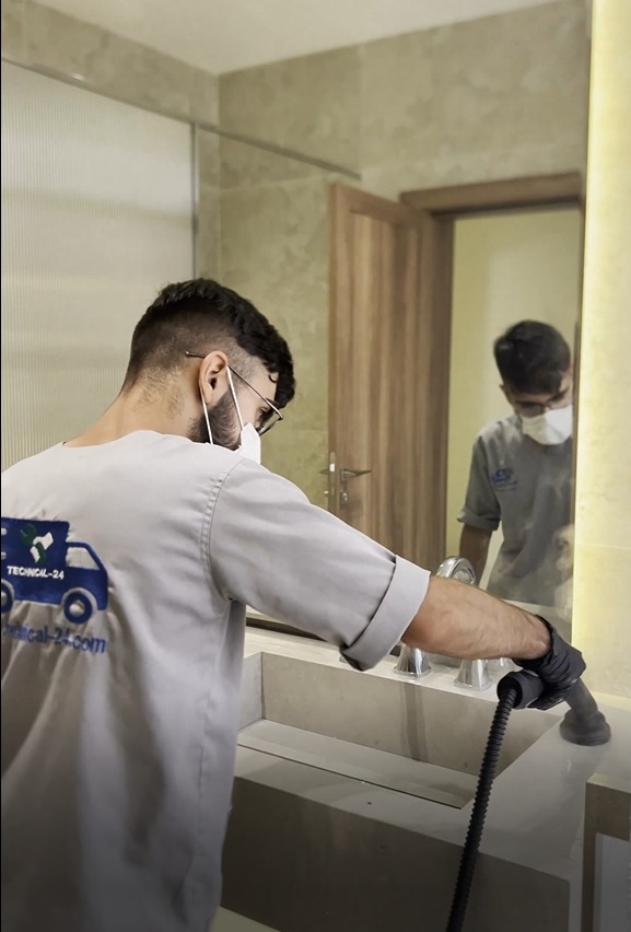 Snow White technician cleaning a bathroom sink